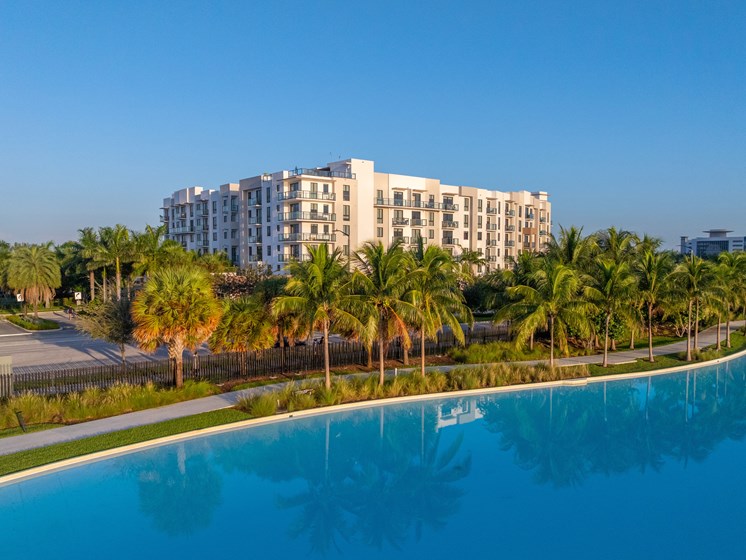 A large white building with a pool in front of it.